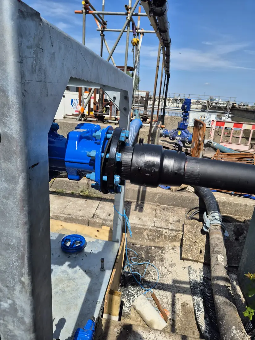Blue ductile-iron water main and valve assembly in an open trench