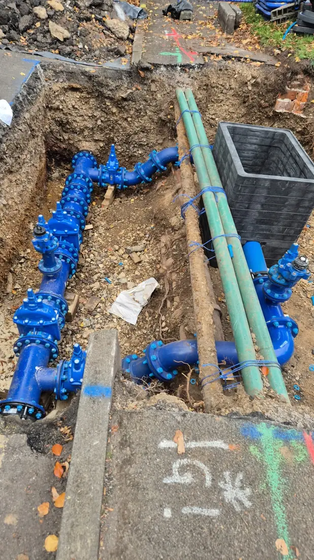 Blue ductile-iron water main and valve assembly in an open trench